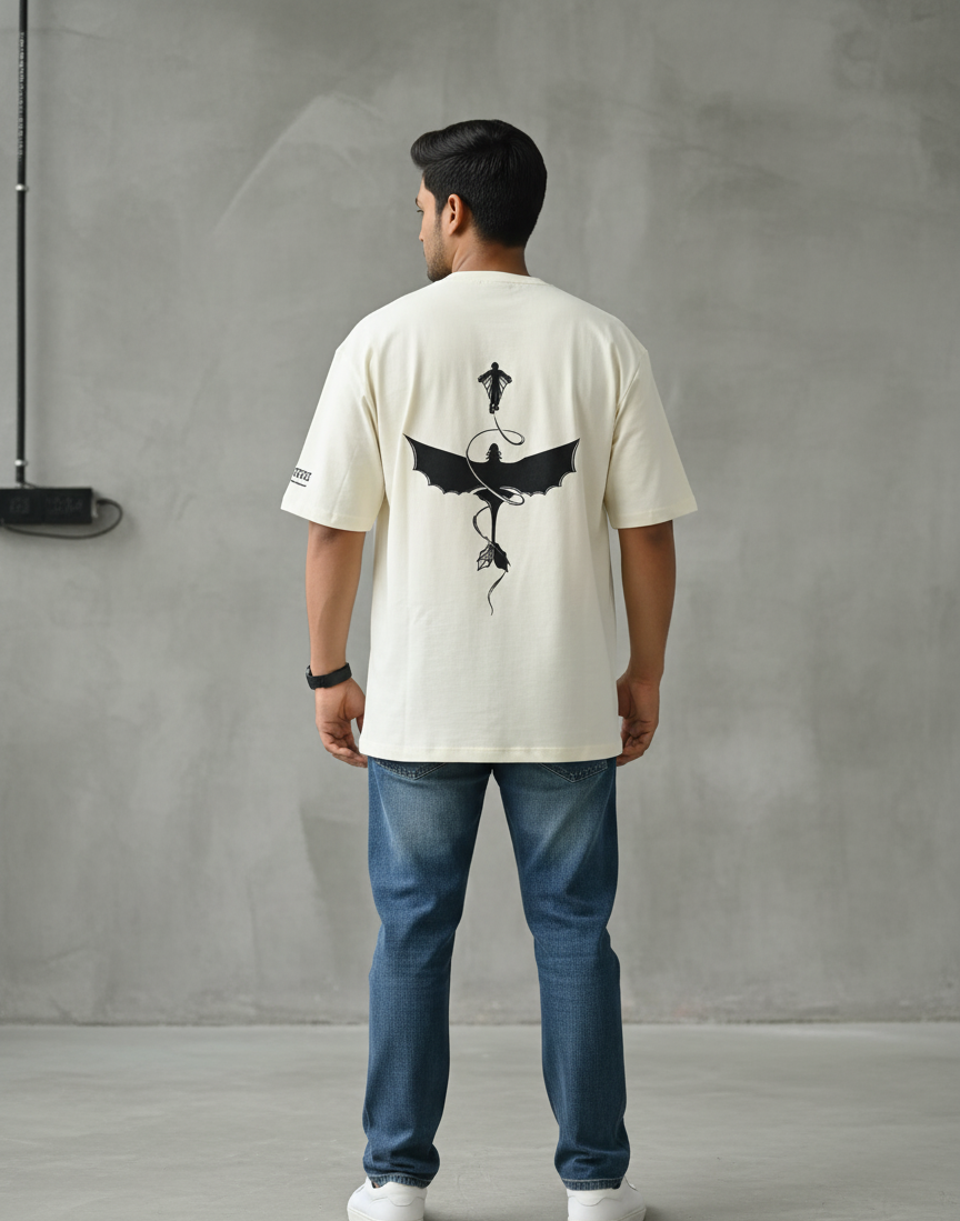 Man wearing a white t-shirt with a black graphic design on the back against a gray wall.