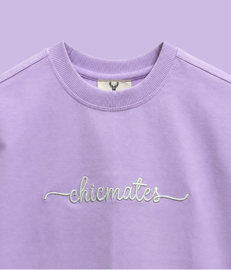 Purple sweatshirt with 'chicmates' embroidery on a light purple background