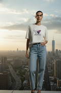 Person wearing a white t-shirt with a butterfly graphic and blue jeans standing against a cityscape background.
